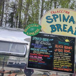 The famous Spinach Bread - Airstream food truck with signs for spinach bread, Brazilian limeade, and black beans and rice bowl.