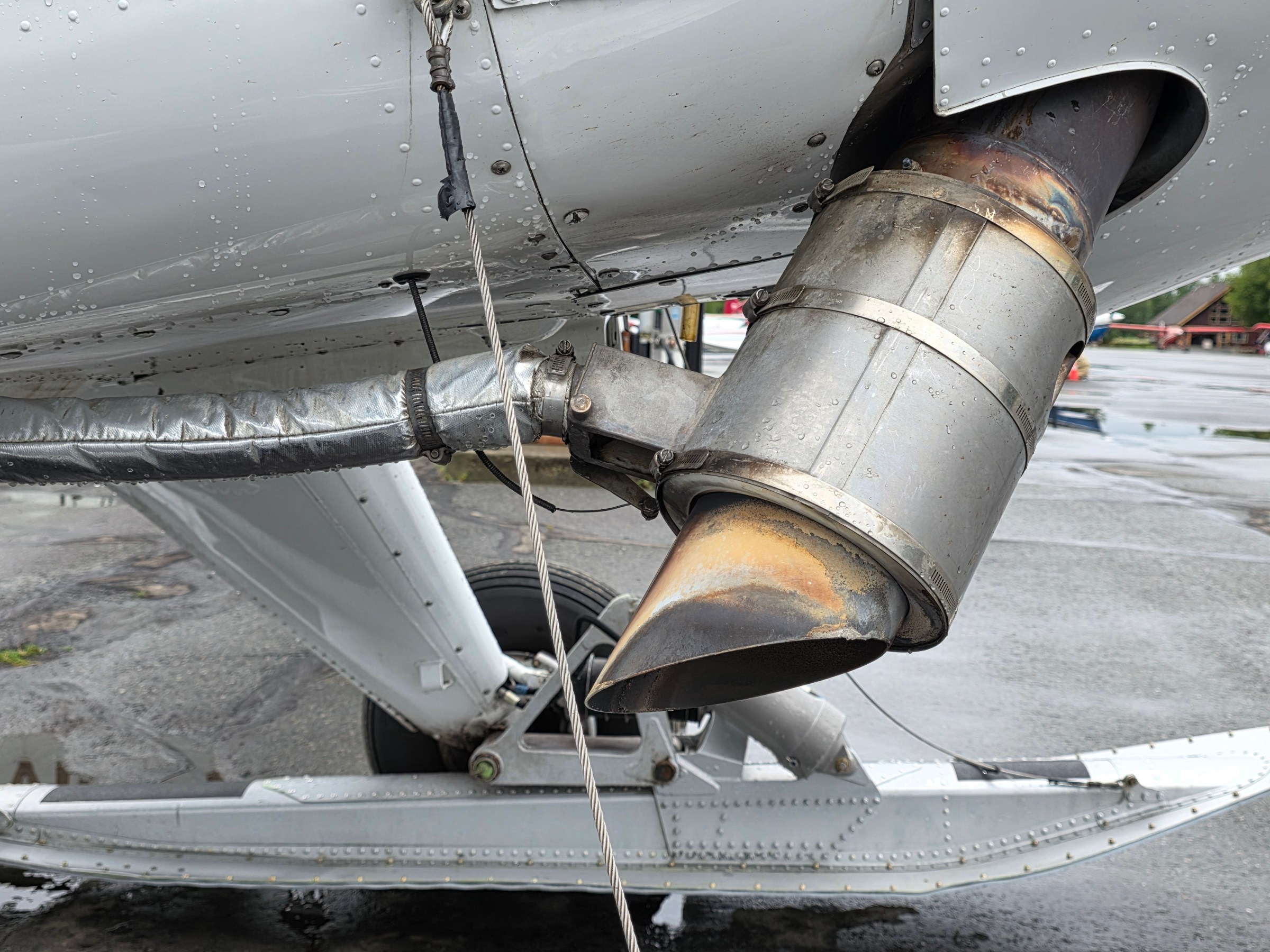 Close-up of a metal exhaust pipe on an aircraft with visible rivets on a Radial Beaver Alaska Bush Plane