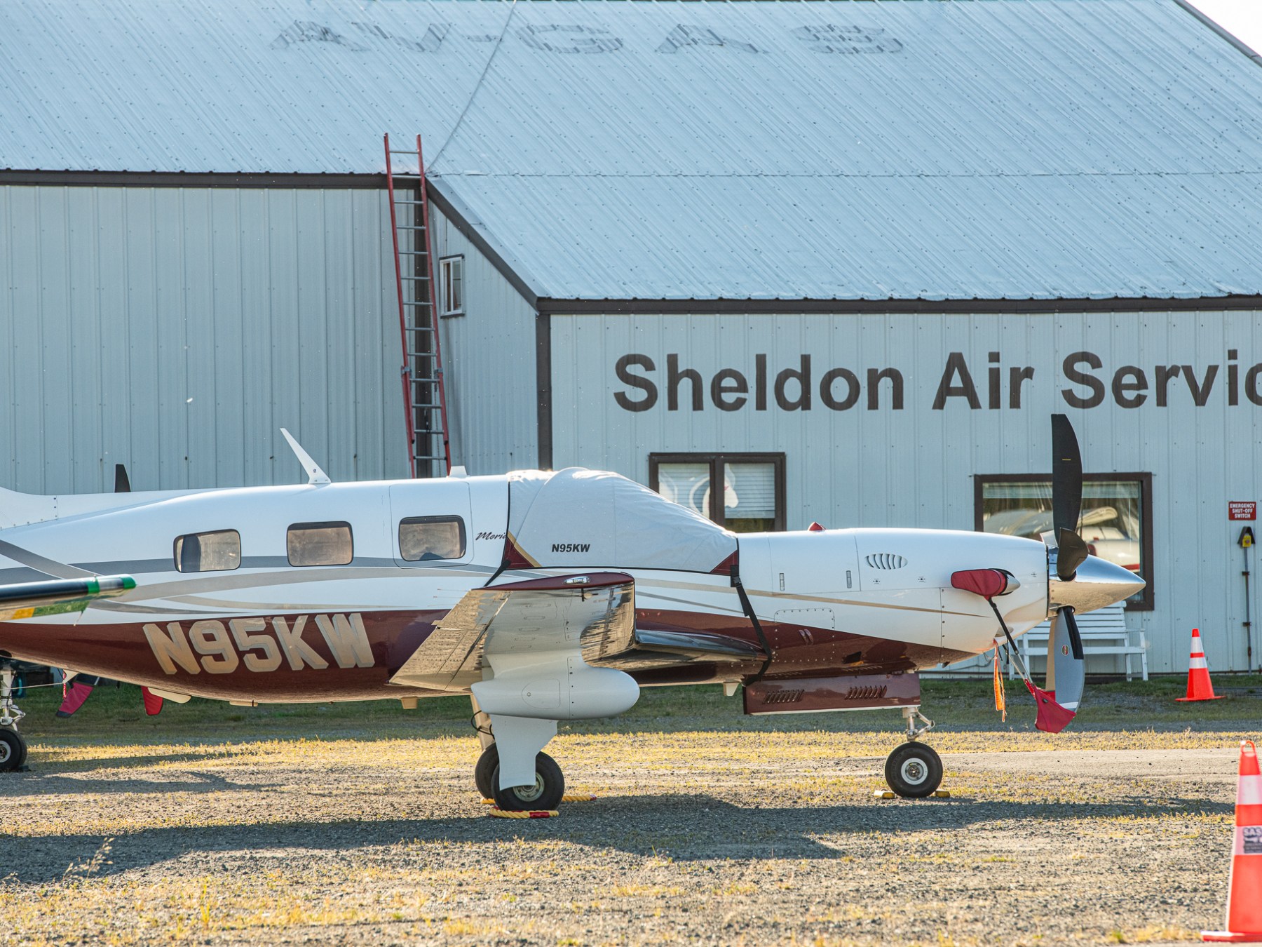 Small airplane parked in front of Sheldon Air Service building.