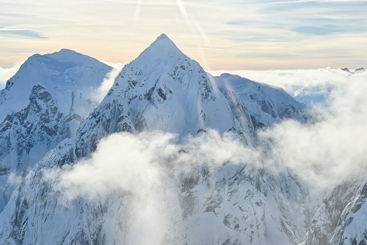 Scenic Denali Winter Tour - Snow-covered mountain peaks with clouds and soft sunlight.