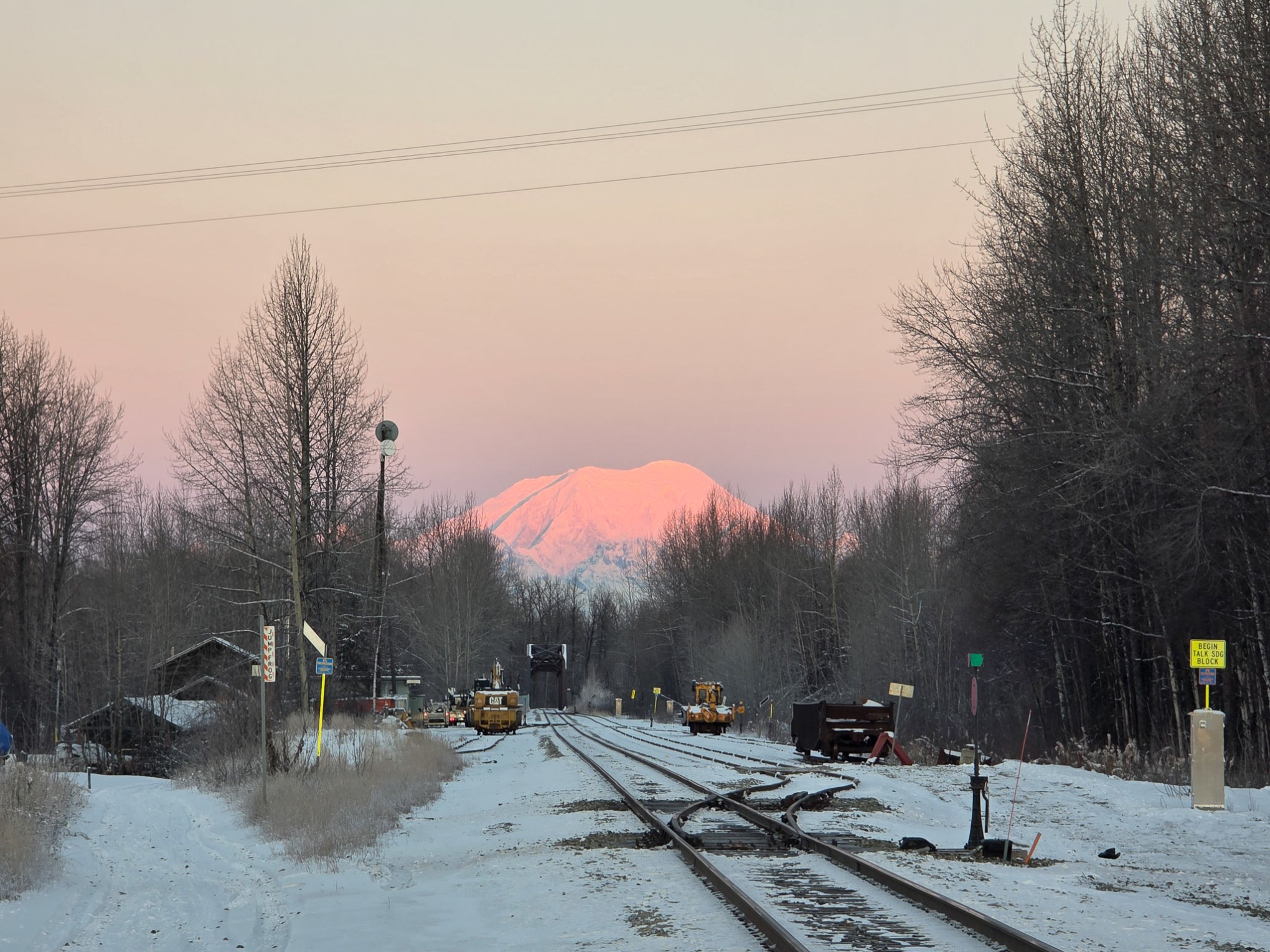 Snowy railroad tracks lead to Foraker under pink sky, winter Talkeetna Views