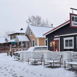 Snowy street with Roadhouse sign and snow-covered benches in main street Talkeetna Alaska