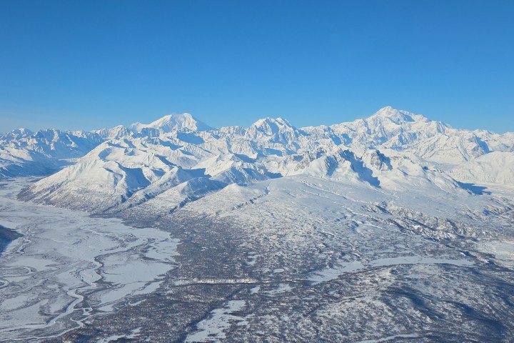 Aerial view of the Tokositna Glacier and the Alaska Range with Mount Foraker, Mount Hunter, and Denali during a winter flightseeing tour from Talkeetna, Alaska.
