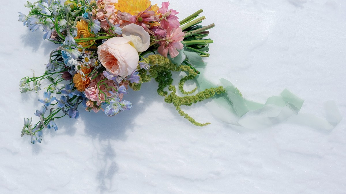 Colorful flower bouquet with ribbon on snow.