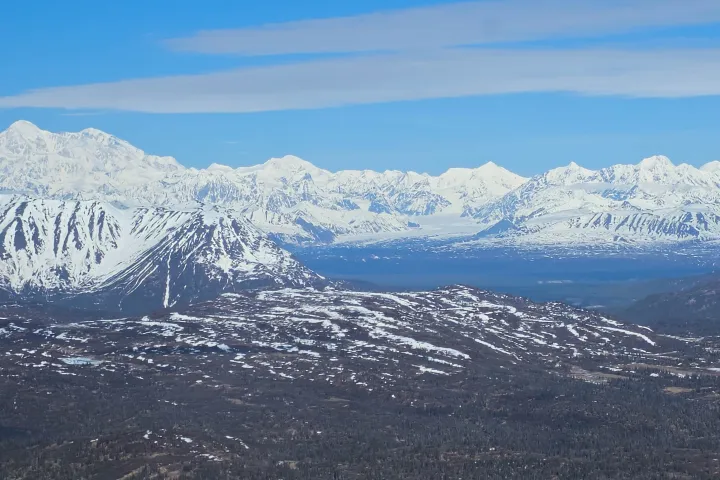 Snow-covered mountains under a clear blue sky in the distance.