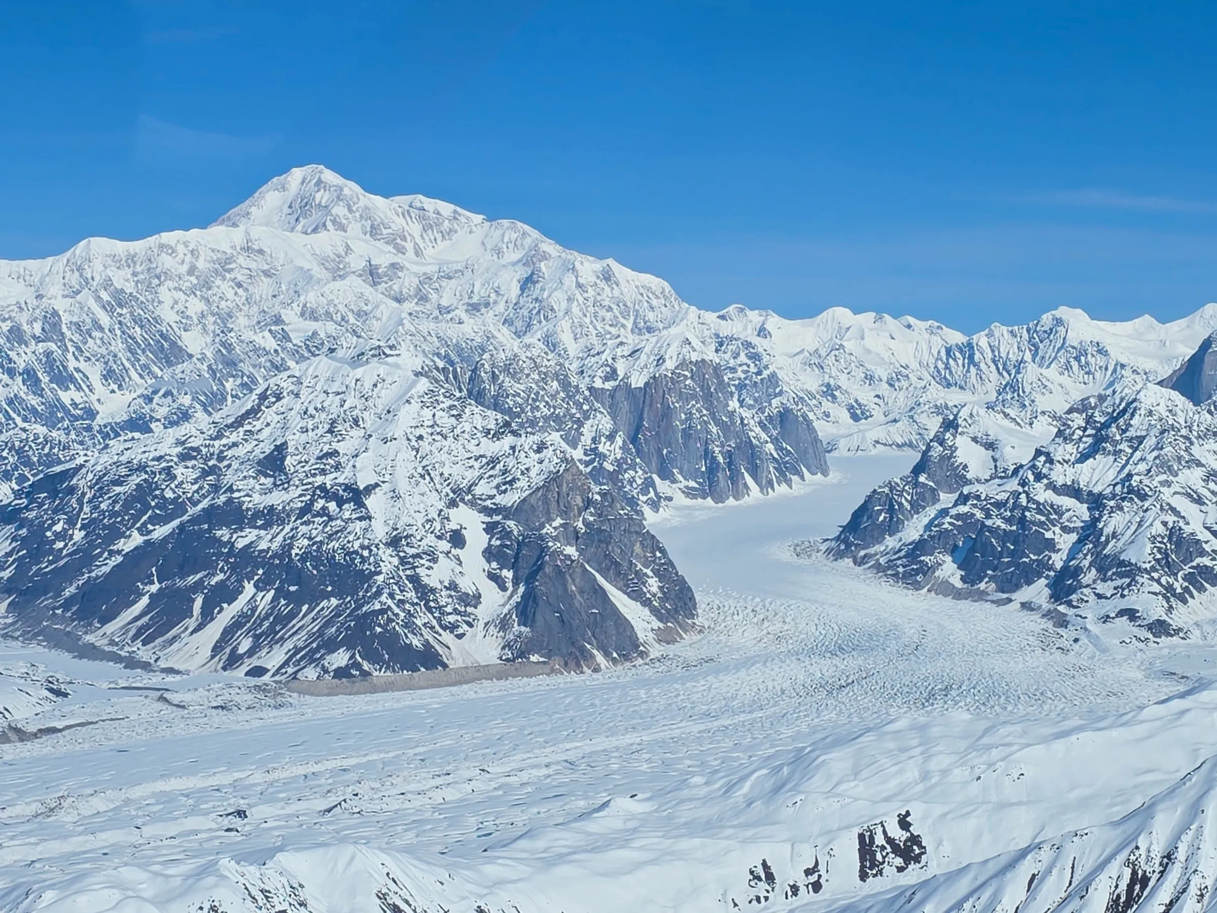 Snow-covered mountains and glacier under a clear blue sky.