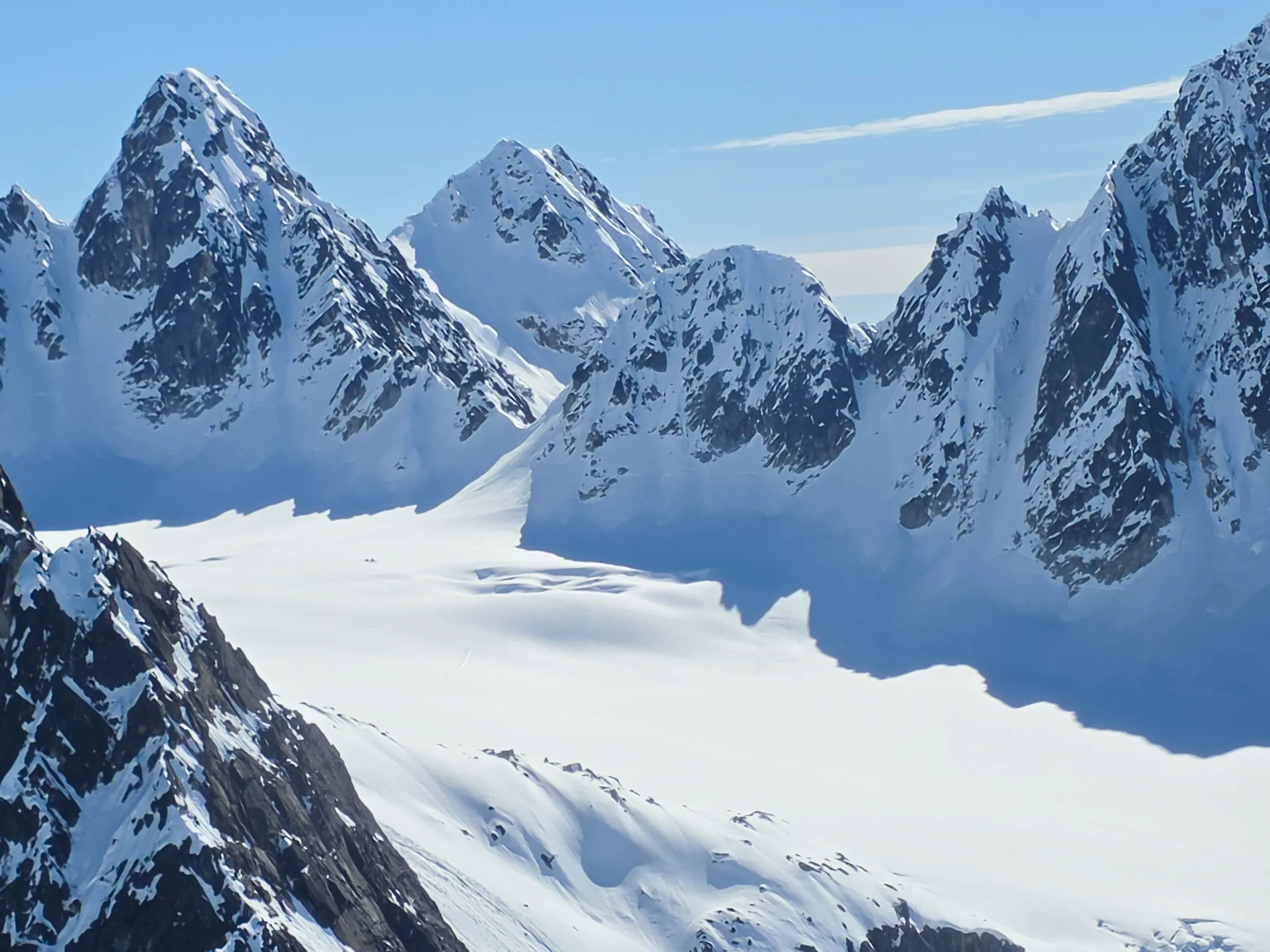 Snow-covered mountain peaks under a clear blue sky.