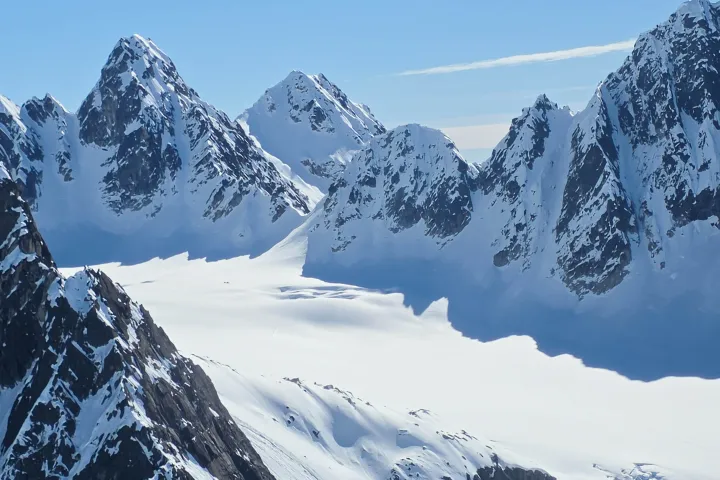 Snow-covered mountain peaks under a clear blue sky.