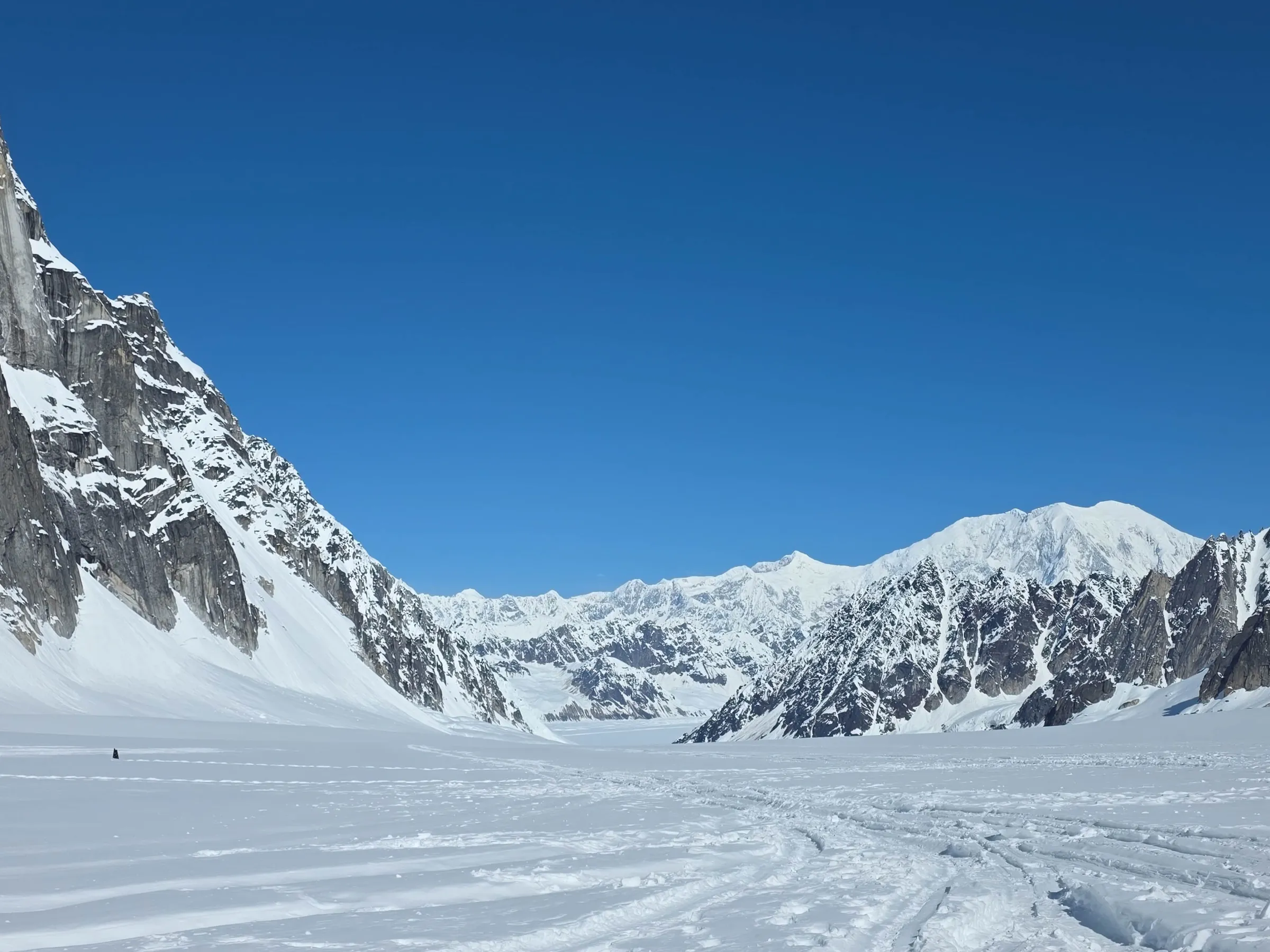 Snow-covered mountains under a clear blue sky.