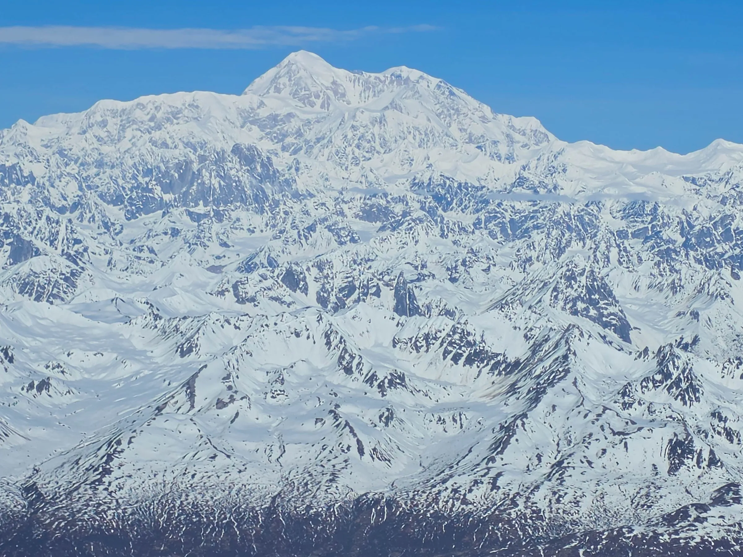 Snow-covered mountain range under a clear blue sky.