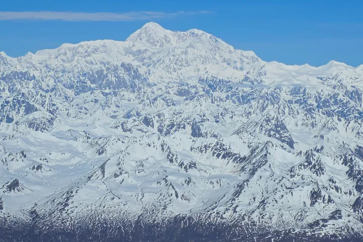 Snow-covered mountain range under a clear blue sky.