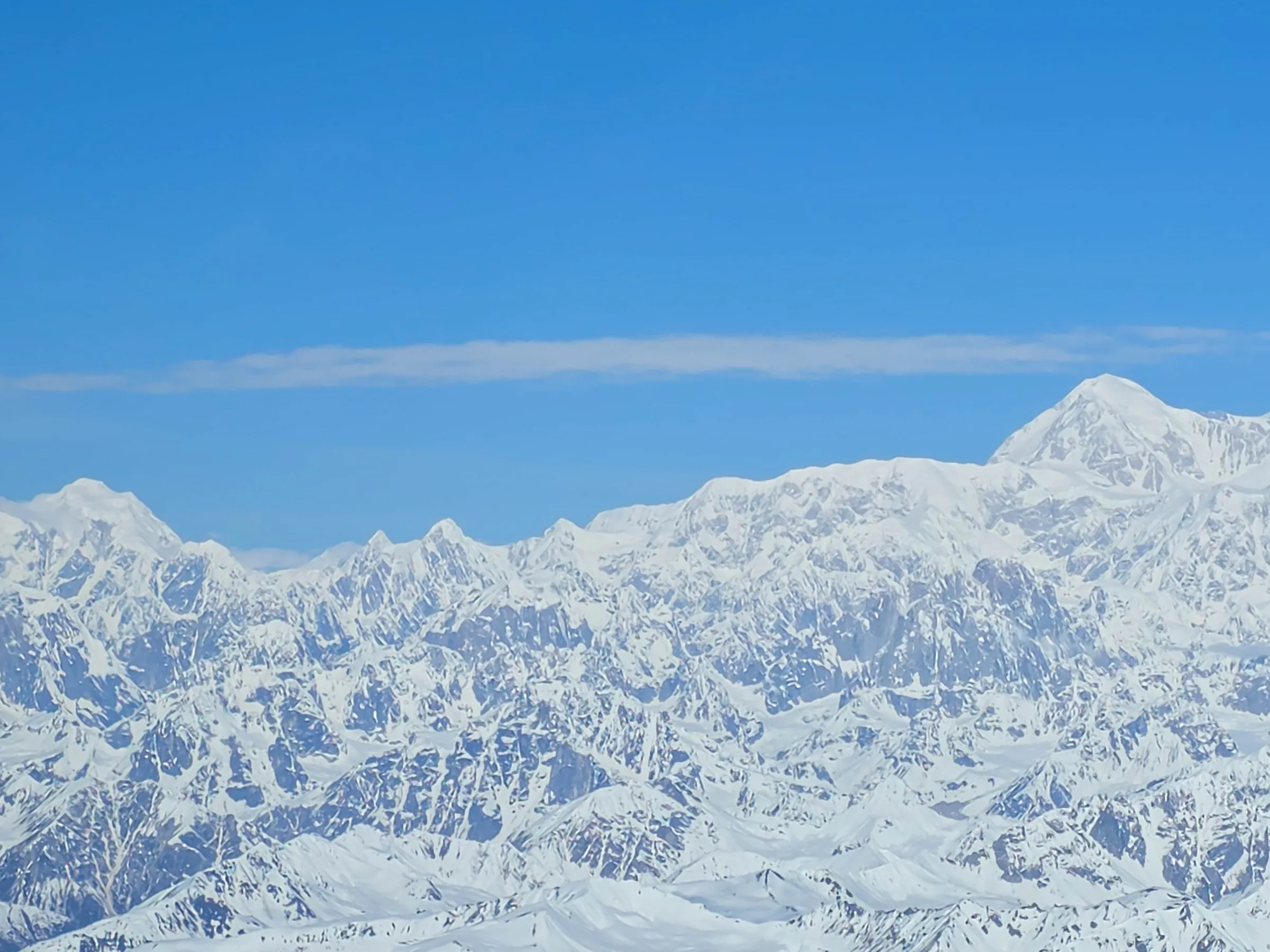 Snow-covered mountain range under a clear blue sky.