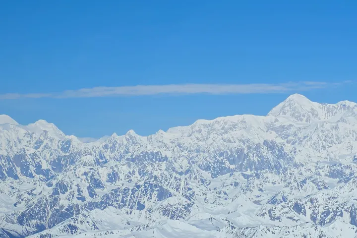 Snow-covered mountain range under a clear blue sky.