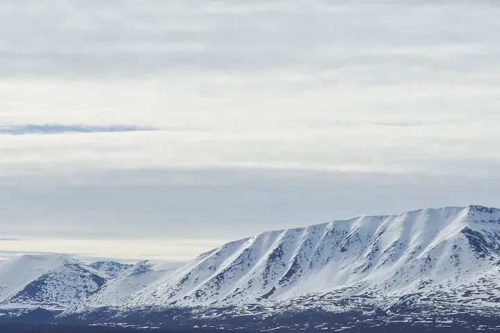 Snow-covered mountains under a cloudy sky.